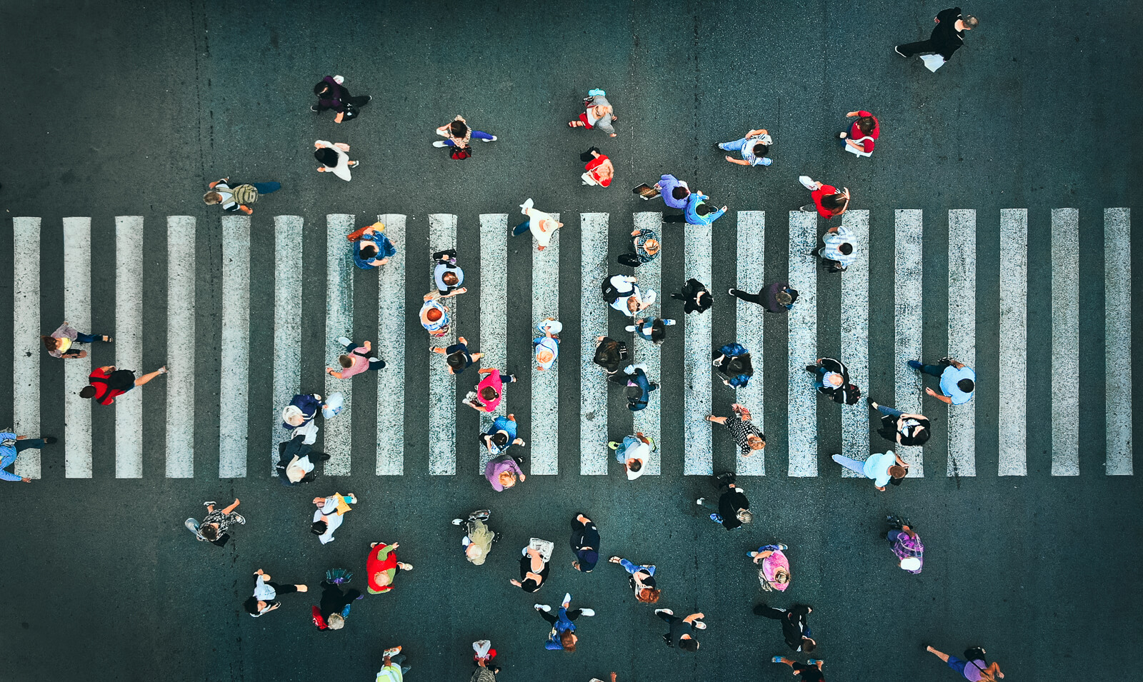 A crosswalk full of people walking.