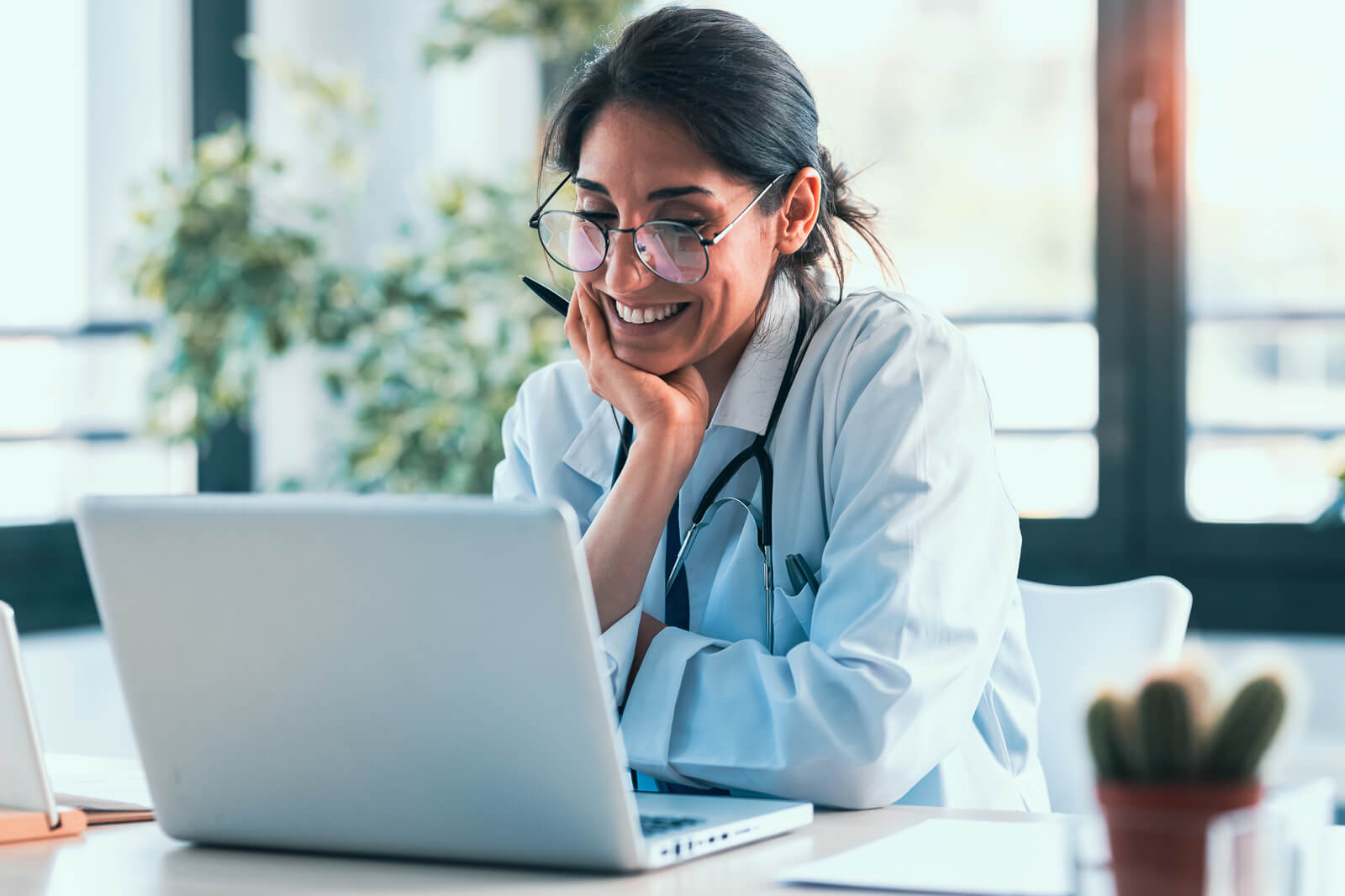 A Healthcare worker smiling at their computer.