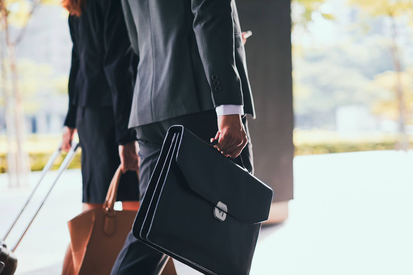 A business man and woman walking with briefcases.